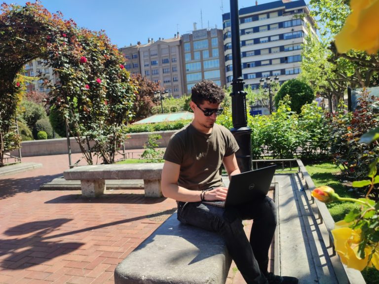 a man sitting on a bench with a laptop. ways to make money online, online jobs, remote work