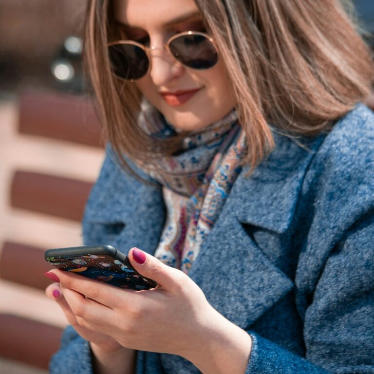 woman in blue coat using smartphone, What contributes to your online identity?